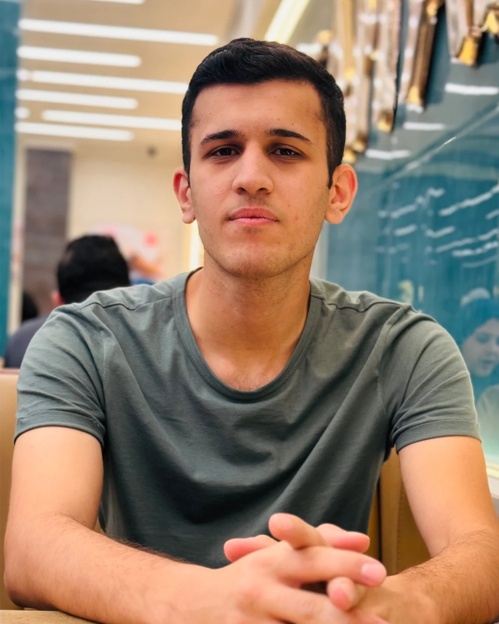 عمر جالس إلى طاولة وينظر إلى الكاميرا